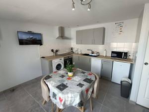 a kitchen with a table and a table and a kitchen with a tableablish at Le Hutteau in Vaudricourt