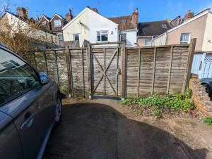 a wooden fence with a gate in front of a house at 5 bed terraced family home Bristol + parking in Bristol