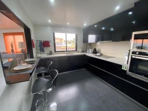 a kitchen with black and white counters and a sink at Villa Madeira island in Caniço