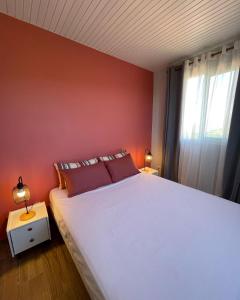 a bedroom with a large white bed and a window at Résidence Terre et Passion in Ducos