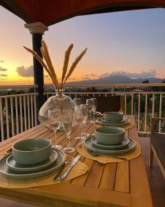 una mesa con platos y copas de vino en el balcón en Résidence Terre et Passion en Ducos