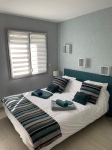 1 dormitorio con 1 cama grande y toallas. en La Maison de l'Auzette, en Limoges