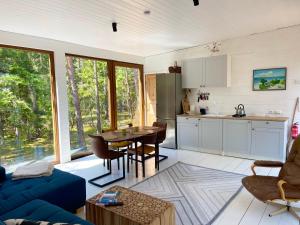 eine Küche und ein Wohnzimmer mit einem blauen Sofa und einem Tisch in der Unterkunft BEACH HOUSE HUBERT in Undva
