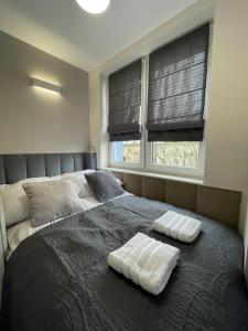 a bedroom with a bed with two towels on it at Przytulny Apartament niedaleko Radomskiego Centrum Sportu in Radom