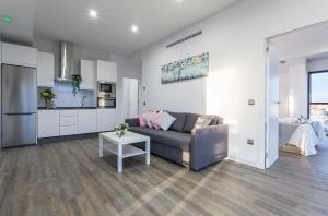 a living room with a couch and a kitchen at New York Style Luxury 3 dormitorios in Jerez de la Frontera