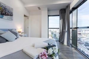 a white bedroom with a large bed with flowers on it at New York Style Luxury 3 dormitorios in Jerez de la Frontera