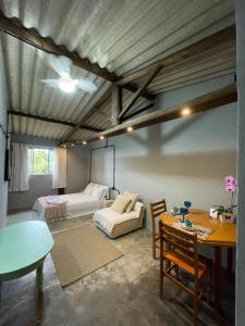 ein Schlafzimmer mit einem Bett, einem Tisch und einem Sofa in der Unterkunft Casa da Rota in São Roque