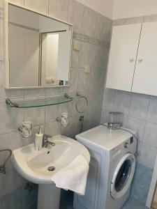 a bathroom with a sink and a washing machine at Apartments Lovro in Lovran