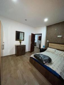 a bedroom with a large bed and a wooden floor at coin du repos in Oujda