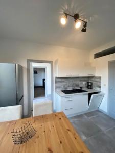 cocina con mesa de madera y nevera en Gite d l'ardoise Privé en Fumay