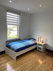 1 dormitorio con cama y ventana en Gite d l'ardoise Privé en Fumay