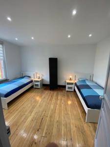 1 dormitorio con 2 camas y 2 mesitas de noche en Gite d l'ardoise Privé en Fumay