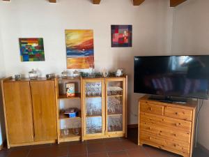 ein Entertainment-Center mit einem Flachbild-TV und einem Holzschrank in der Unterkunft Ferienhaus Strandfuchs, Hooksiel in Wangerland