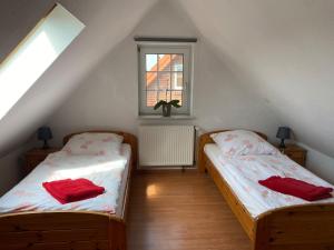 Zimmer im Dachgeschoss mit 2 Betten und einem Fenster in der Unterkunft Ferienhaus Strandfuchs, Hooksiel in Wangerland