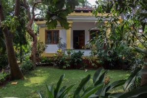 a house with a garden in front of it at LUISA BY THE SEA VILLAS in Cavelossim