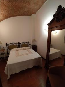 sypialnia z łóżkiem i dużym lustrem w obiekcie Palazzo Turro Bed & Breakfast w mieście Podenzano