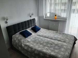 a bedroom with a large bed with blue pillows at Apartament całoroczny Bliżej Morza in Kołobrzeg