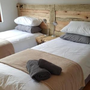 a bedroom with two beds with towels on the bed at JBay Surfed Out in Jeffreys Bay