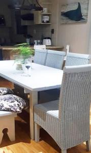una mesa y sillas blancas con una copa de vino en JBay Surfed Out, en Jeffreys Bay