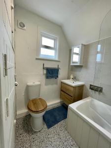 ein Badezimmer mit einem WC, einer Badewanne und einem Waschbecken in der Unterkunft Cosy Coastal 2-Bedroom Cottage with Hot Tub and Log Burner in West Mersea