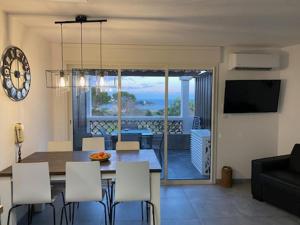 comedor y sala de estar con mesa y sillas en Cap Esterel Appartement haut de gamme en Saint-Raphaël