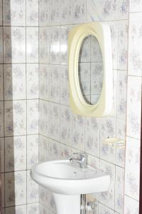 a bathroom with a sink and a mirror at TRIPLE GUEST HOUSE in Ruhengeri