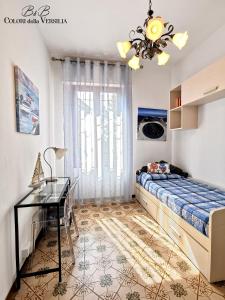 een slaapkamer met een bed, een bureau en een raam bij colori della versilia in Montignoso