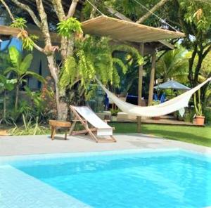 una piscina con una hamaca junto a un complejo en Pé na Areia - Pousada en Barra Grande