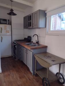 a small kitchen with a sink and a refrigerator at Refugio de Mar - Reta - Casa Contenedor in Balneario Reta +10 photos
