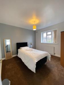 1 dormitorio con 1 cama blanca grande y ventana en budget private rooms close to city centre and airport, en Birmingham