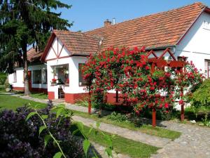 una casa blanca con flores rojas delante en Guest House St. Mária, en Máriapócs
