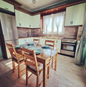 a kitchen with a table and chairs and a stove at Tararas apartments in Néa Michanióna