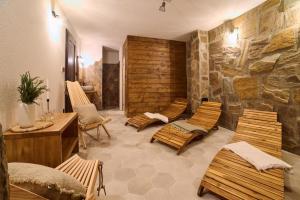 a room with chairs and a stone wall at Drevenice Kaskády Oščadnica Veľká Rača in Oščadnica