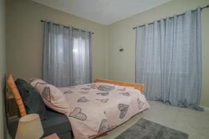 Schlafzimmer mit einem Bett und einem Fenster mit Vorhängen in der Unterkunft Bridge Brazen in Edessa