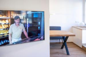 TV en una cocina con un hombre en una nevera en Concordia33 - Traumferienwohnung an der Regnitz en Bamberg
