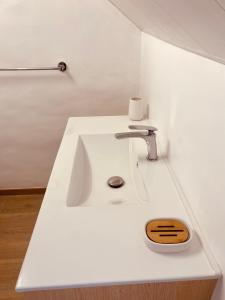 Cette chambre blanche comprend un lavabo blanc. dans l'établissement LOFT T2 en couleur en plein centre ville Fort-De-France Martinique, à Fort-de-France