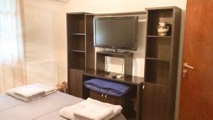 a room with a tv and a bed with towels at Paz y armonía cerca de todo in San Salvador de Jujuy
