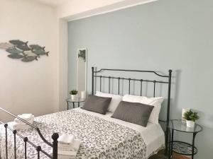 サン・ヴィート・ロ・カーポにあるLa terrazza nel Bluのベッドルーム1室(黒と白のベッド1台、テーブル2台付)