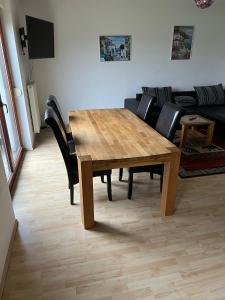 una mesa de madera y sillas en la sala de estar. en Bennstedt 1, en Salzatal