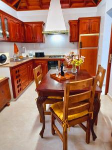 uma cozinha com uma mesa de madeira com cadeiras e um frigorífico em La casa de Isabel em Mazo