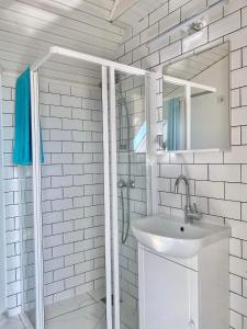 bagno bianco con lavandino e doccia di DONATICOEUR Bellevue a Budapest