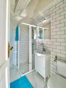 een witte badkamer met een douche en een wastafel bij DONATICOEUR Bellevue in Boedapest