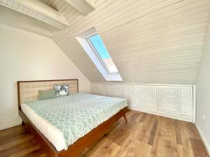 a attic bedroom with a bed with a window at DONATICOEUR Bellevue in Budapest