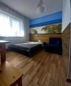 a bedroom with a bed and a couch and a table at Leśne Zacisze in Nickelswalde