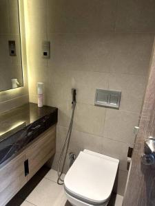 uma casa de banho com um WC branco e um lavatório. em Cozy Al Raha Beach Home em Abu Dhabi