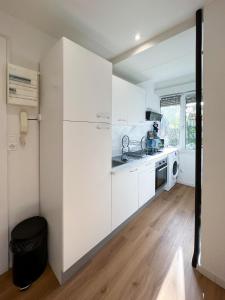 a white kitchen with a sink and a refrigerator at Appart'Hotel Le Tilleul - NETFLIX, JARDIN ET FIBRE OPTIQUE in Belfort
