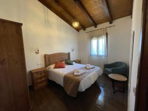 een slaapkamer met een bed, een tafel en een stoel bij APARTAMENTOS DOÑA JIMENA DEL AMBROZ 4 Estrellas complejo único en el centro del pueblo - PISCINA YA ABIERTA in Hervás