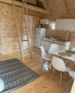 - une cuisine avec une table et des chaises dans une cabine dans l'établissement Domek letniskowy nad jeziorem, à Marksoby