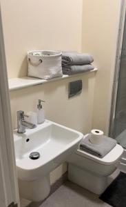a bathroom with a sink and a toilet and towels at Two Bed Town Apartment in Rotherham