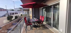 a table and chairs on a balcony with an umbrella at Terraços da Baía - São Martinho do Porto in São Martinho do Porto
